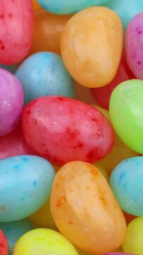 Bright colorful fruit jelly beans circle rotation close up, vertical video format