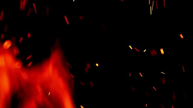 Glowing Fire Sparks and Hot Embers Rising from Intense Flames. heat, energy, and volatile nature of combustion, often seen in campfires, fireplaces, or controlled burns.