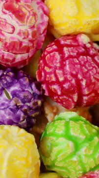 Bright colorful fruit caramel popcorn circle rotation close up, vertical video format