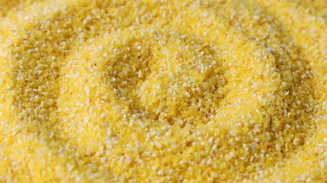 Yellow corn grain flour for polenta porridge circle rotation close up