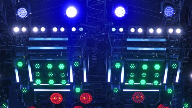 Concert stage lighting equipment creating colorful blue, green, and red illumination at event
