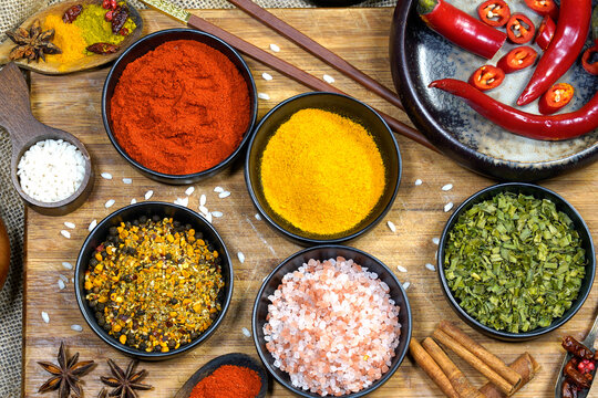 Natura morta. Still life riso con spezie colorate in polvere e grani su vassoio nero e yuta