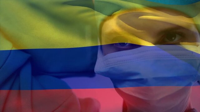 Animation of waving colombia flag against caucasian female surgeon wearing surgical mask at hospital