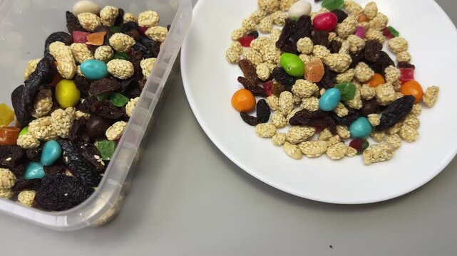 Nuts, dried fruits, candied fruits in container and on dish
