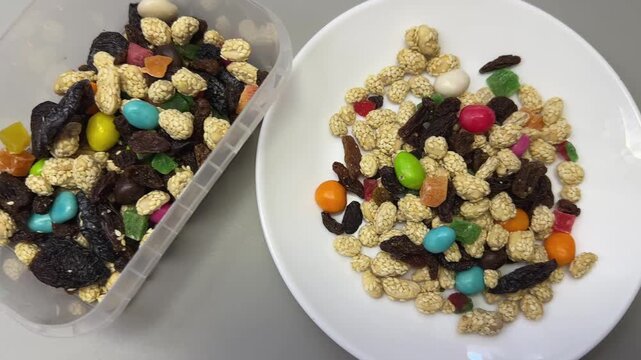 Nuts, dried fruits, candied fruits in container and on dish