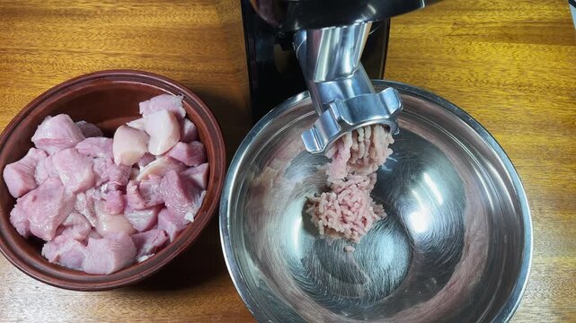 Starting grinding turkey into ground meat with electric meat grinder