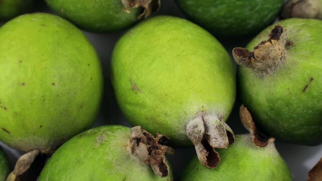 Green feijoa fruit circle rotation close up top view
