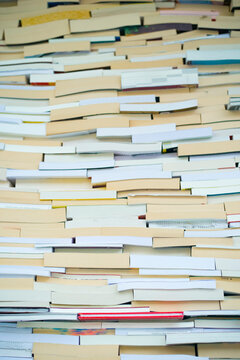 Stacked books with varied covers creating a colorful, textured pattern. Brussels, Belgium