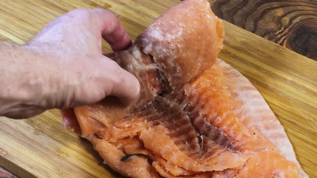 Unrolling of roll of twisted raw thawed slices of salmon