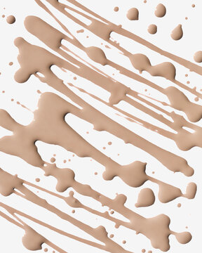 Beige make-up liquid droplets and splatters on a white background in an abstract pattern