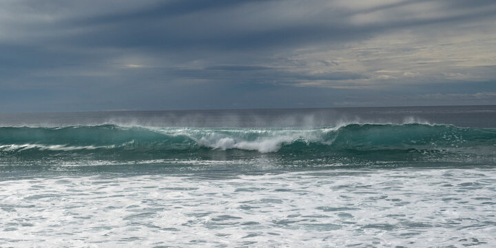 Ocean waves crashing under a cloudy, overcast sky with a distant horizon. Todos Santos, Baja California, Mexico