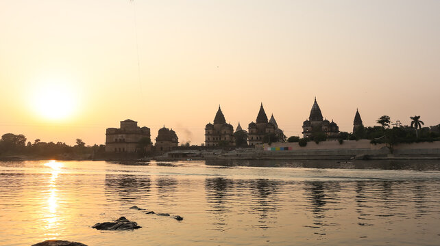 Orchha cenotaphs Silhouette in warm sunset light along Betwa River, Madhya Pradesh, India.