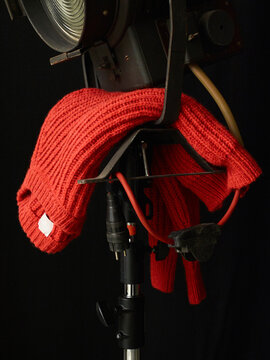 A red knitted sweater draped over a stage light against a black background. Germany