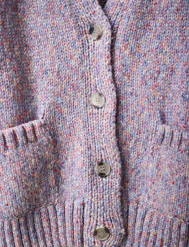 Multicolored wool cardigan with buttons and pockets in close-up view. Germany