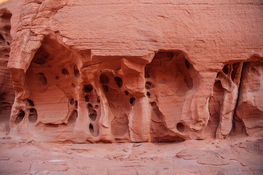 Eroded red rock formations with natural holes and textures in a desert landscape. WA, USA