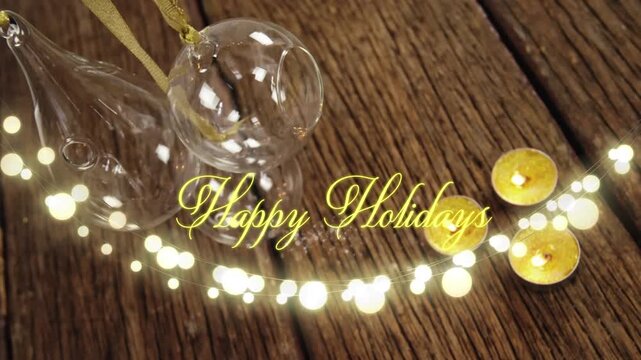 Animation of text, happy holidays, in yellow, over string lights, marshmallows and xmas decorations