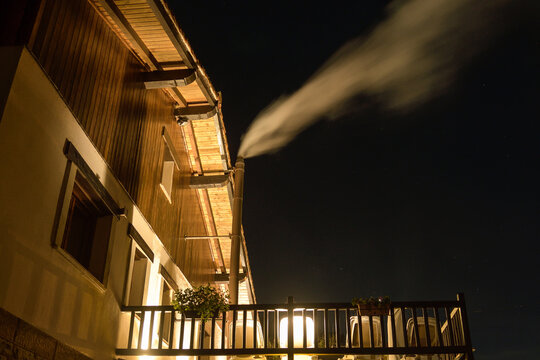 Farmhouse with smoke rising from the chimney at dusk