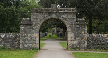 Obraz premium Catholic cemetery stone arch entrance incorporating copy space for text