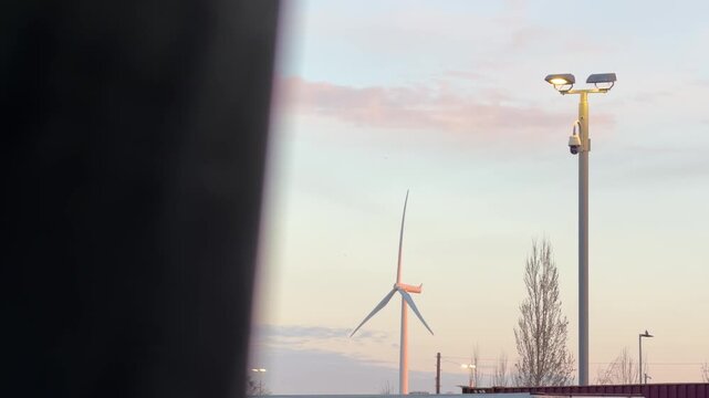 Spinning wind turbine against colorful twilight detail