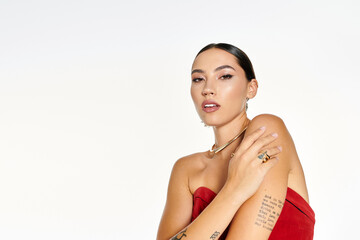 Fototapeta premium Beautiful young woman in a stunning red outfit showcases elegance and charm in a bright setting