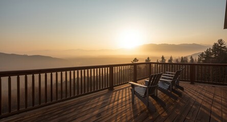 Fototapeta premium Morning haze casts a peaceful mood over a wooden deck with Adirondack chairs and mountain views