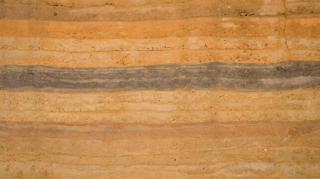 Rammed earth wall texture detail in sustainable building showcasing natural material layers