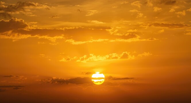 Luminous yellow sunset with fluffy cloud layers and clear copy space background