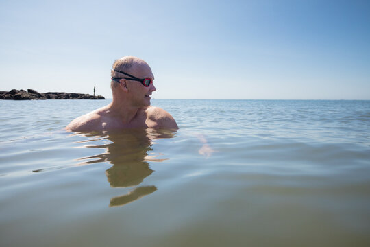 Male open water swimmer wearing goggles looking to the right