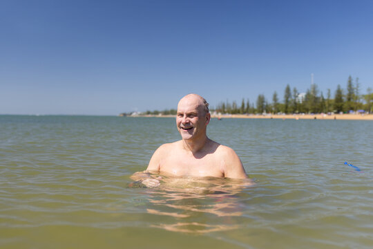 Male open water swimmer standing in the water