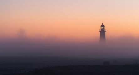 Fototapeta premium Lighthouse silhouette in soft dawn fog