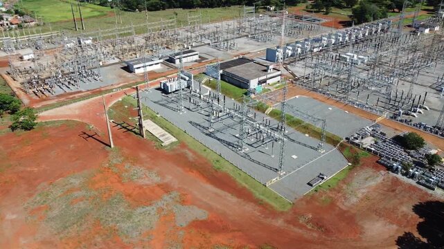 Dynamic drone orbit shot circling an expansive high-voltage electrical substation in Goiania, Brazil, highlighting the complex network of transformers and power grid infrastructure.