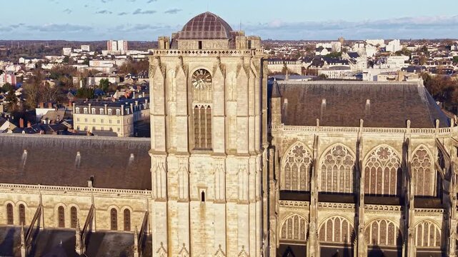 Close-up drone fly of the Le Mans Cathedral aka Cathedral of Saint Julian south side with ornate gothic facade details and clock, Le Mans, France