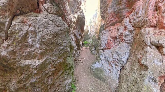 Narrow trail winding between towering sandstone walls of Quebrada del Toro in Lagunas de Ruidera Natural Park, showcasing rugged, untouched canyon scenery and geology. Ossa de Montiel, Albacete
