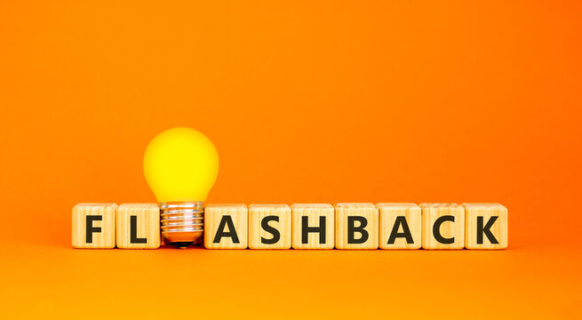 Flashback symbol. Concept word Flashback on beautiful wooden blocks. Beautiful orange background. Beautiful yellow light bulb. Business education flashback concept. Copy space.