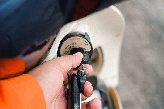 Person Hand Turning Key in Scooter Ignition Switch to Start the Motor Vehicle Transportation for Daily Commuting Travel