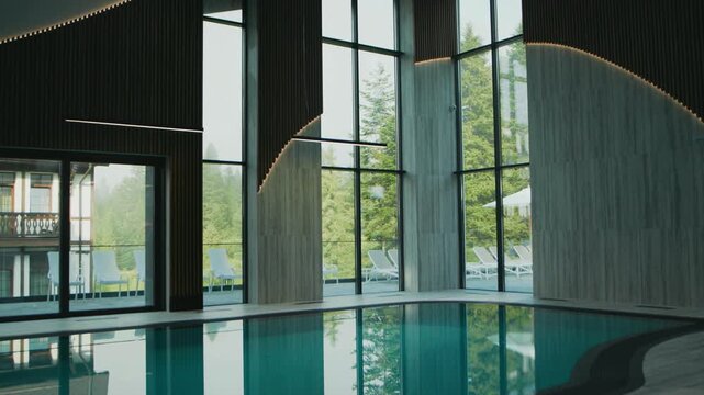 Beautiful indoor Swimming pool with large panoramic windows, lighting and finished in loft style.