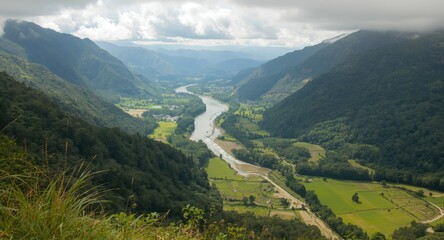 Naklejka premium Lush river valley extending across green open fields