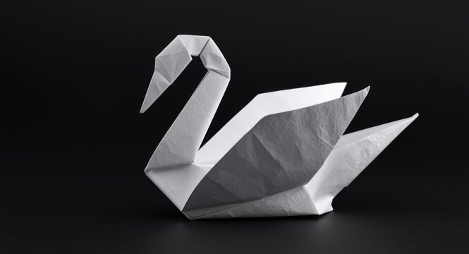 An elaborate origami swan formed with careful white paper folds and textures