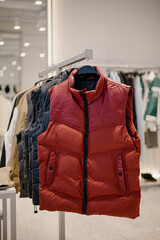 Red men's puffer vest with a zipper in a modern clothing store © bo.kvk