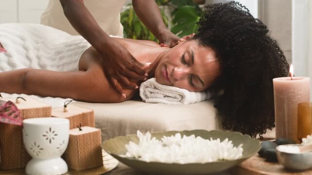Beautiful Black Woman Relishing a Relaxing Back Massage During a Tranquil Spa Treatment