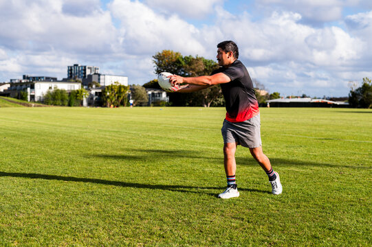 An athlete is executing a precise throw while training on a bright, clear afternoon