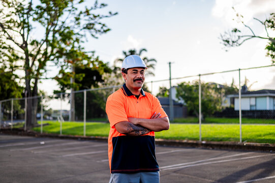 A construction worker dressed in bright orange high vis top and hard hat