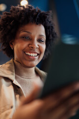 Happy woman using digital tablet outdoors at urban location, cheerful freelancer working on mobile...