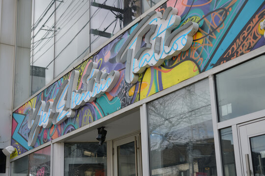 exterior building facade and sign of Yes Electric Tattoo, a tattoo shop, located at 499 Queen St W, Toronto