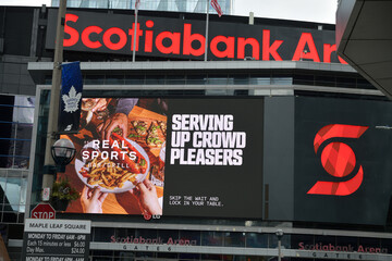 Naklejka premium Scotiabank Arena (Maple Leaf Square LED sign) with advertisement for Real Sports Bar & Grill (15 York St), Toronto