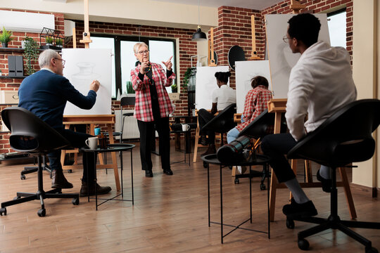 Learning to draw from proffesional instructor, diverse different aged people attending art class, enjoying recreational drawing in group. Artistic creative activities for adults