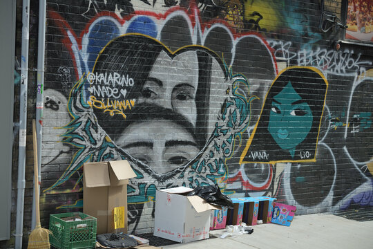 discarded and toppled "Nerds" candy cardboard standing display unit outside in a lane with a lot of street art in Toronto