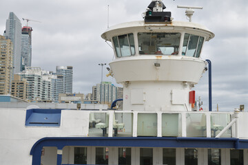 Naklejka premium tour boat with prominent bridge structure in Toronto harbor, with view of mostly condominium complexes 