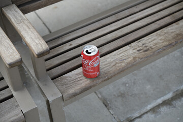 Naklejka premium discarded Coca-Cola can on a public bench in Toronto