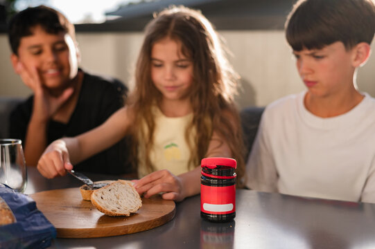 Young girl with long hair spreading marmite on a slice of bread